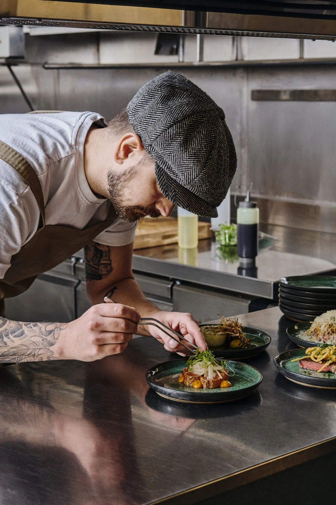 A professional chef places garnishes on a plate of food with a pair of tweezers, the right tools will allow you to plate like a pro. 