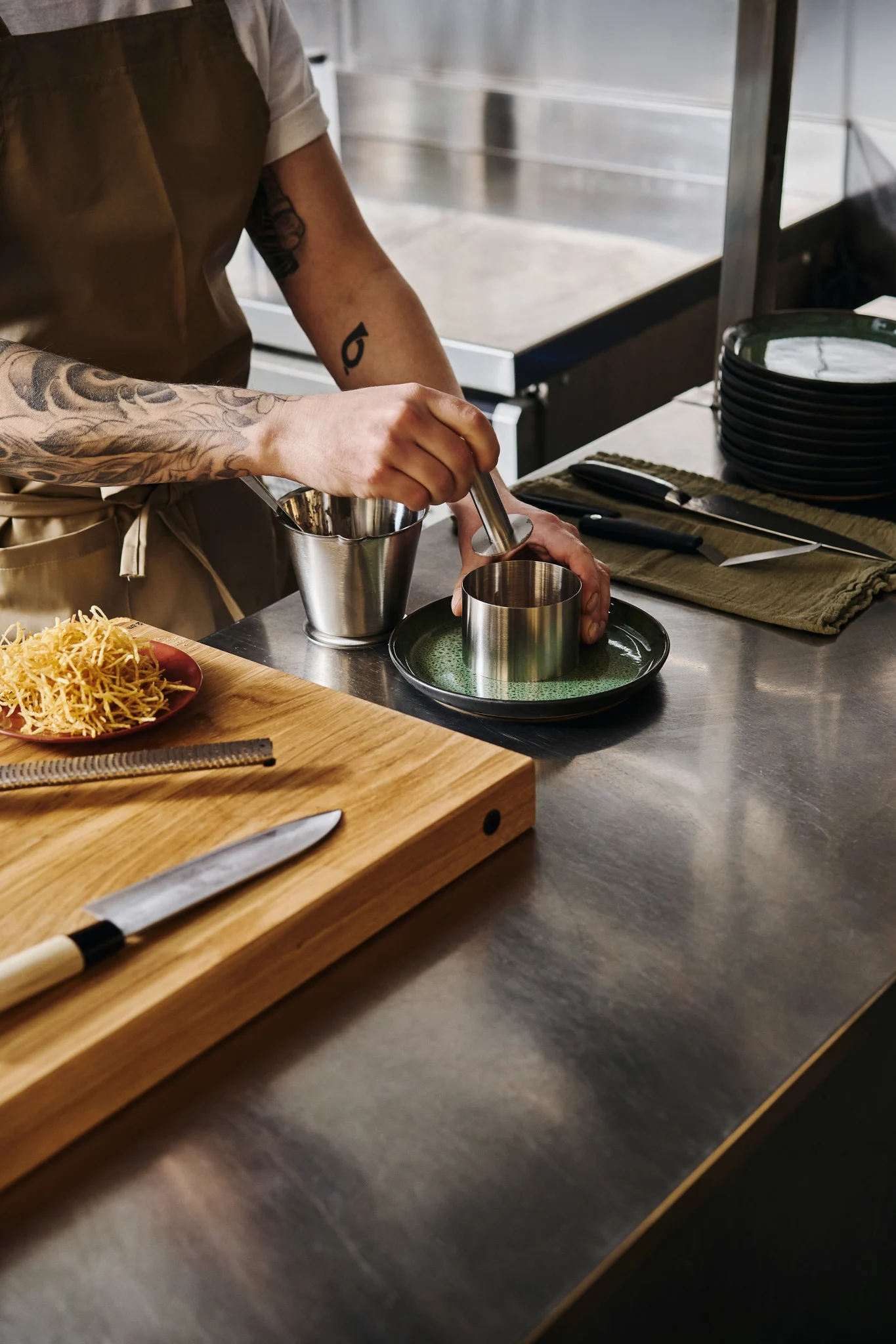 Learn how to plate like a pro: here you see a professional chef plating a dish using a round stainless steel plating ring. 