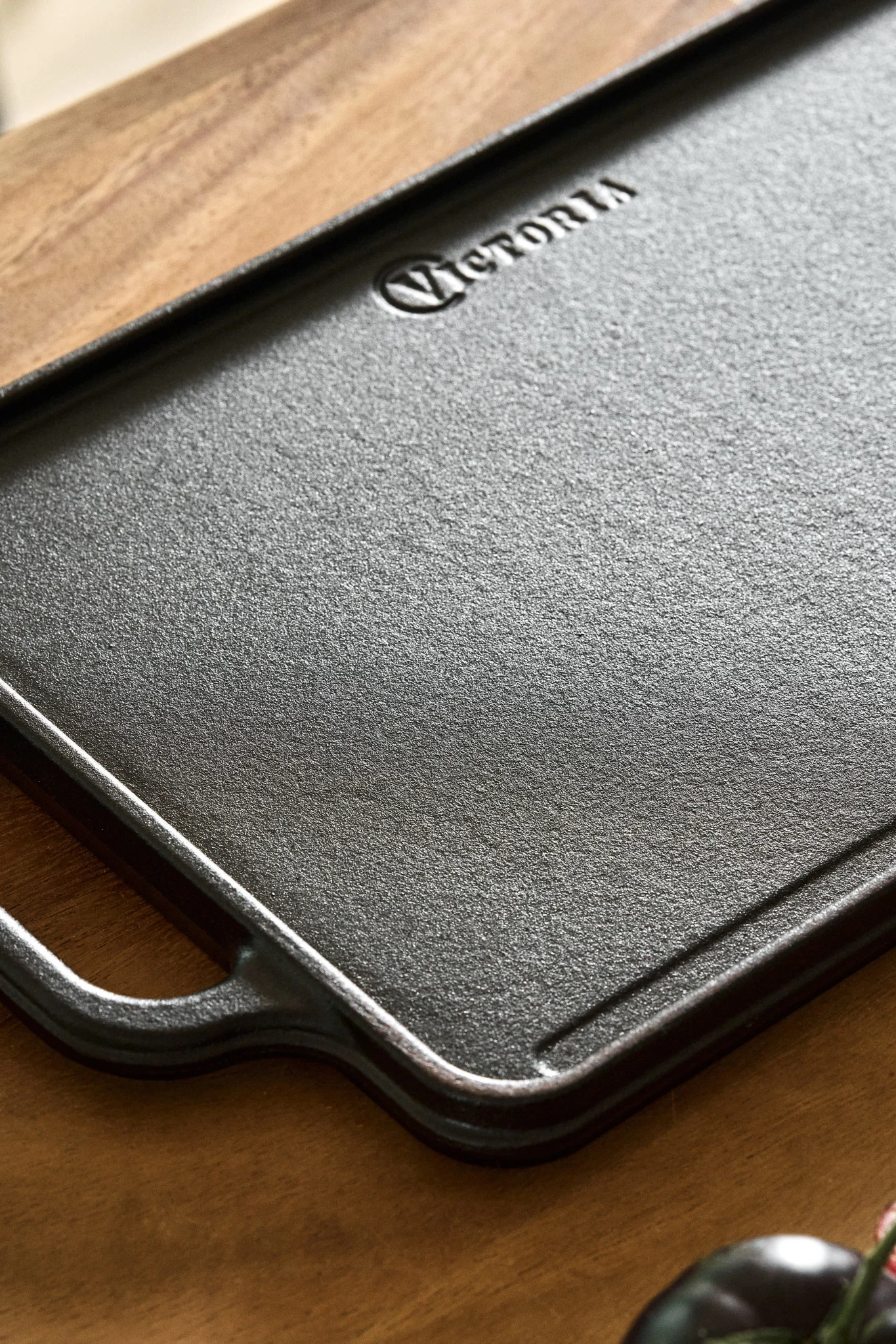 A reversible cast iron cooking plate on a wooden kitchen side. 