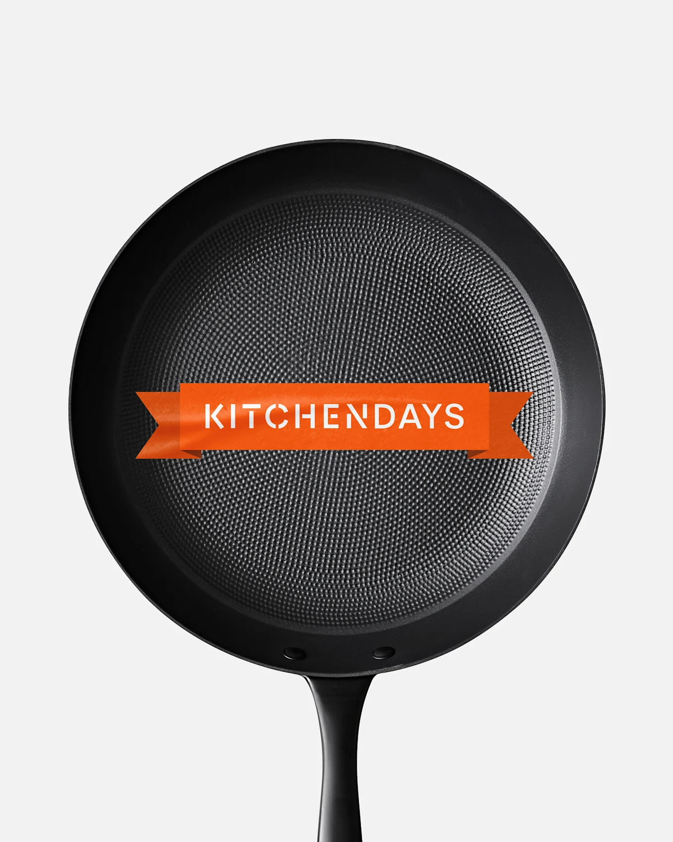 Black frying pan with a textured surface and an orange banner across the center displaying 'KITCHENDAYS'.