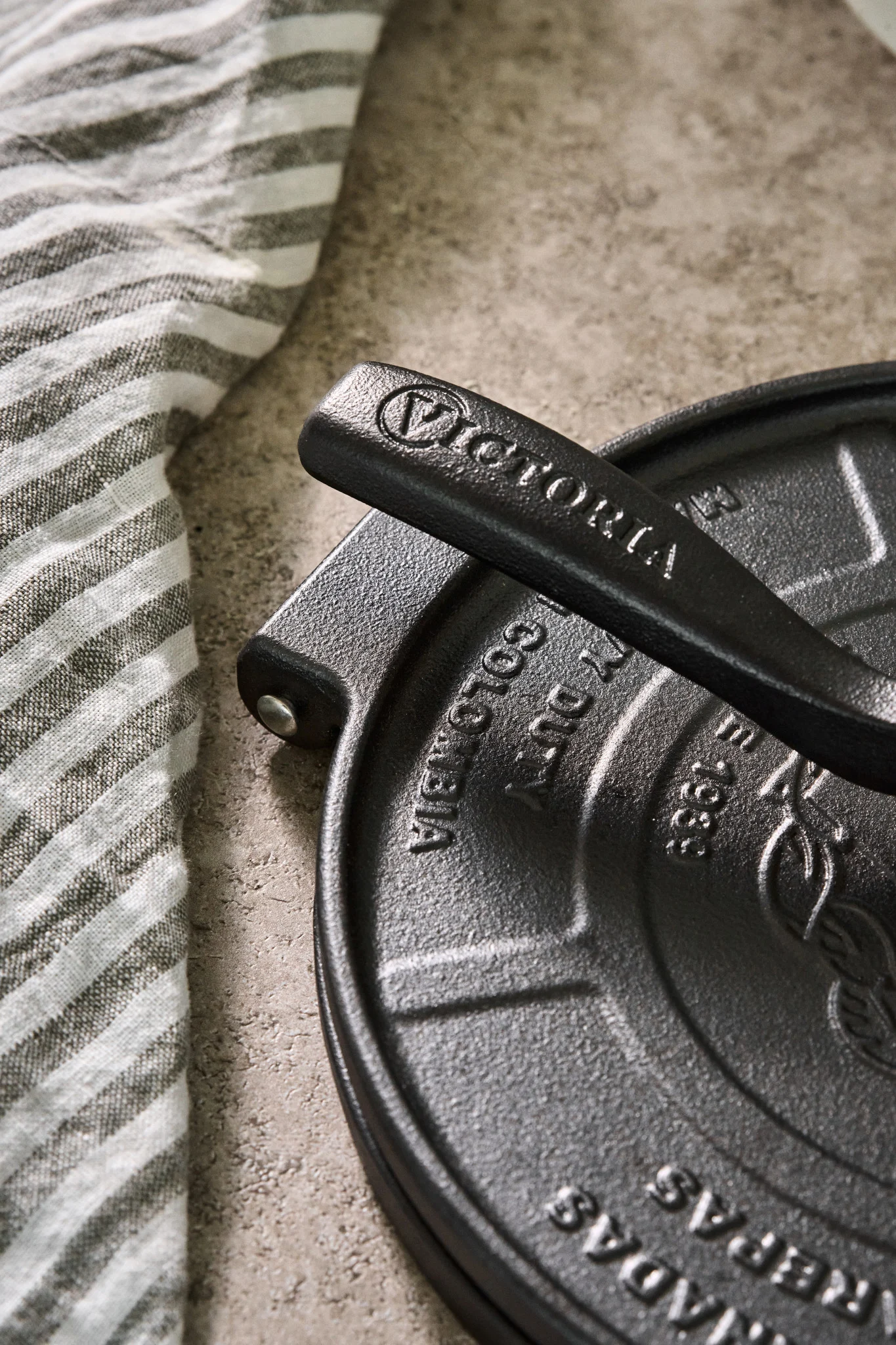 A close up of the handle on a cast iron tortilla press from Victoria. 